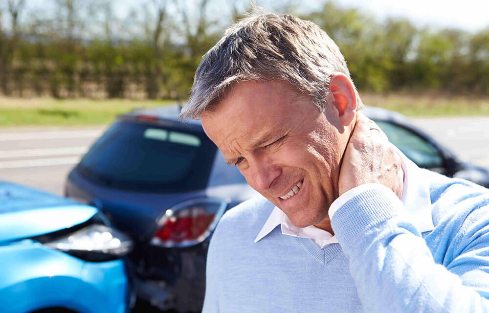 driver standing having neck pain after car accident